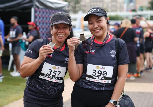 Brisbane10_two-female-competitors-in-run-army-shirts-smiling-holding-up-their-medals